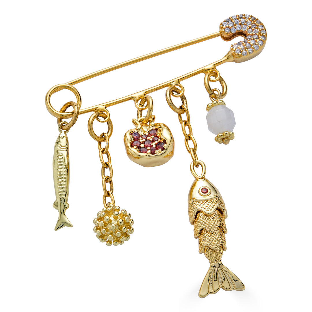 Gold charm brooch with fish charms, pomegranate charm, and dangling textured accents.