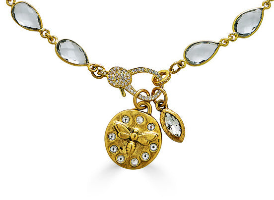 A gold crystal chain necklace with a crystal bee charm