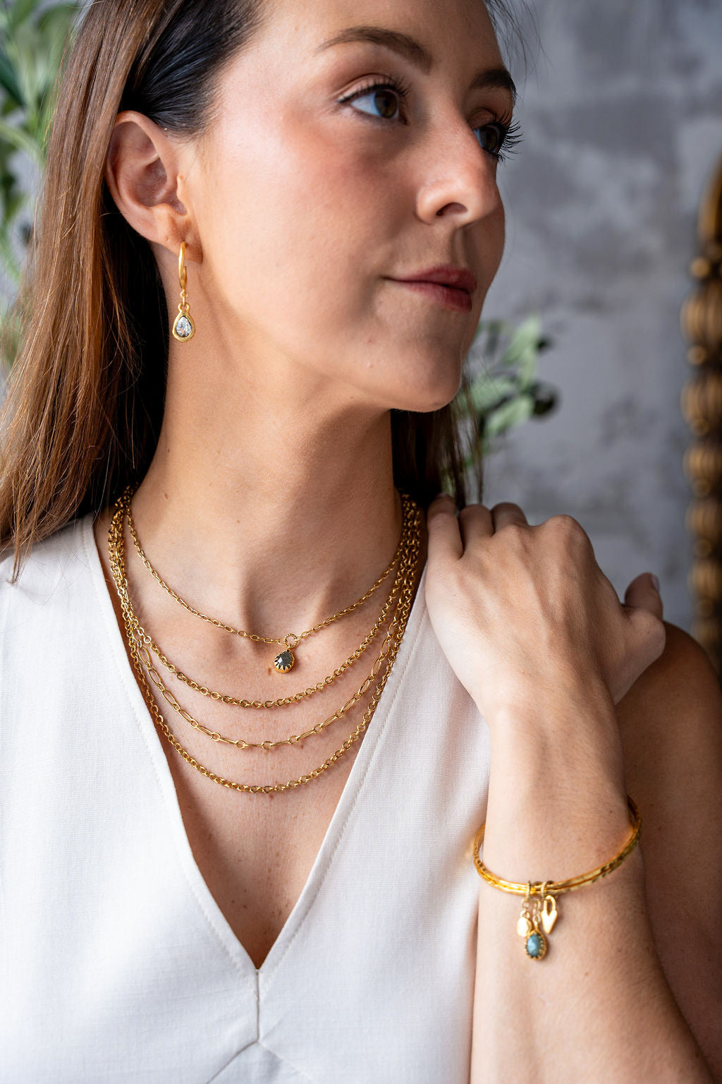 Gold three-strand necklace featuring delicate mixed chain styles and adjustable clasp