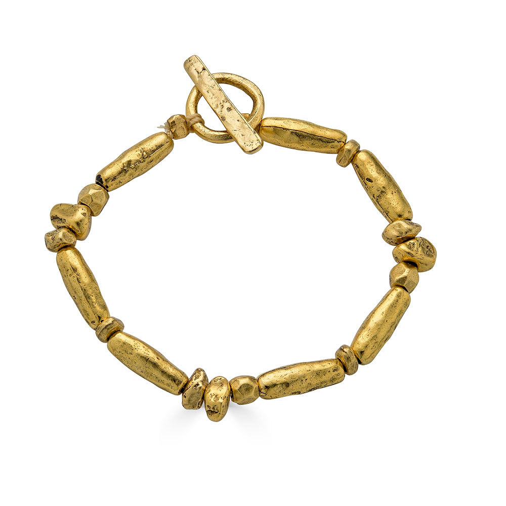 Gold-toned bracelet with sculptural organic beads and a toggle clasp, styled in a circular shape.