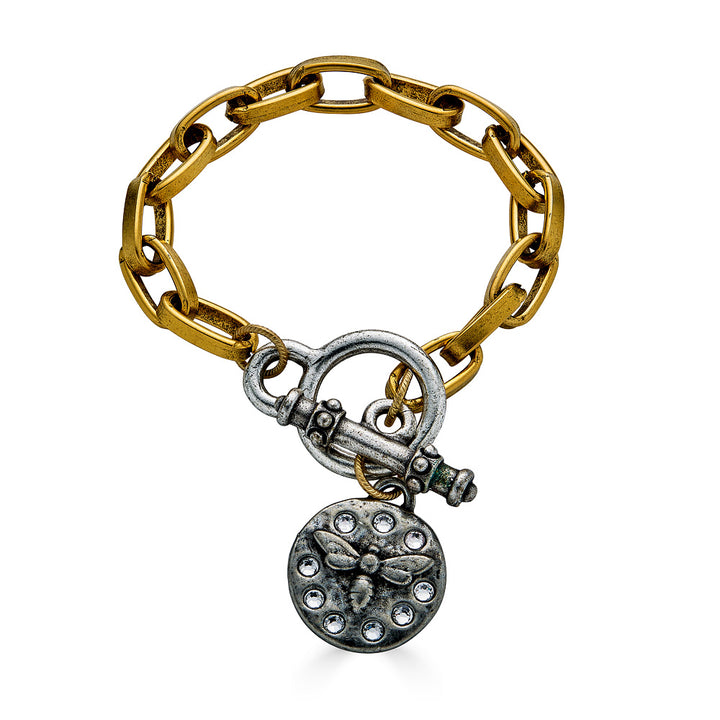 A gold paperclip link bracelet with a silver bee charm and toggle clasp.