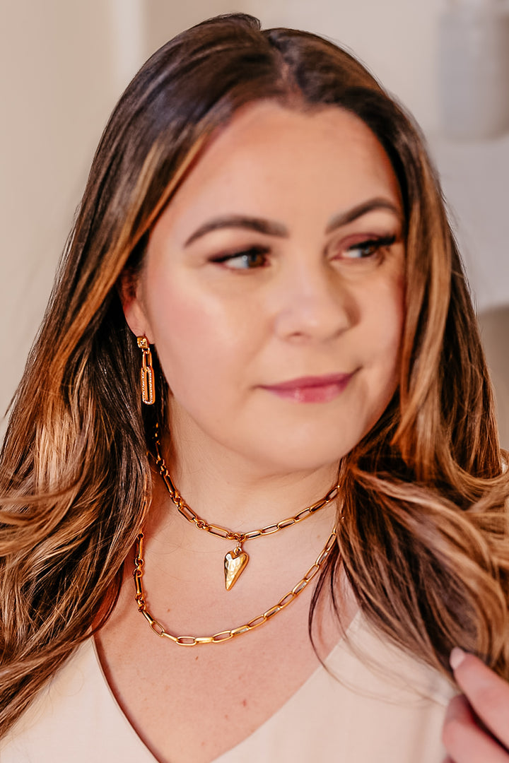 A model wearing A mixed chain necklace with a skinny heart pendant.