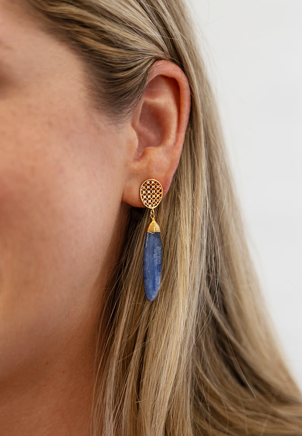 A kyanite dangle earring on an oval pave post