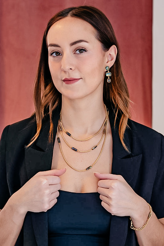 A model wearing A box chain necklace with baguette cut labradorite gemstones.