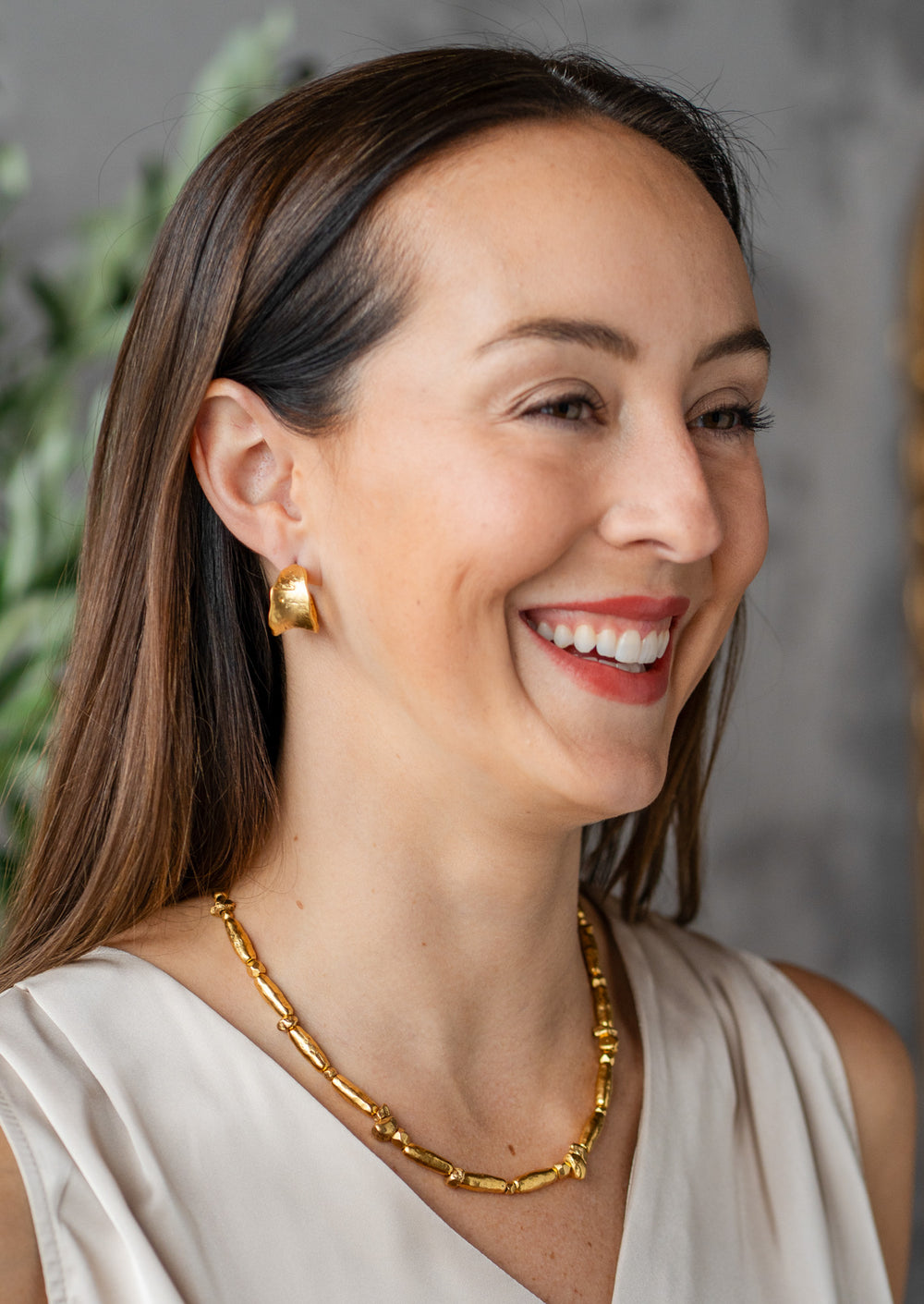 Gold necklace with organic, elongated and irregular bead shapes spaced along a double strand chain, finished with an adjustable clasp.