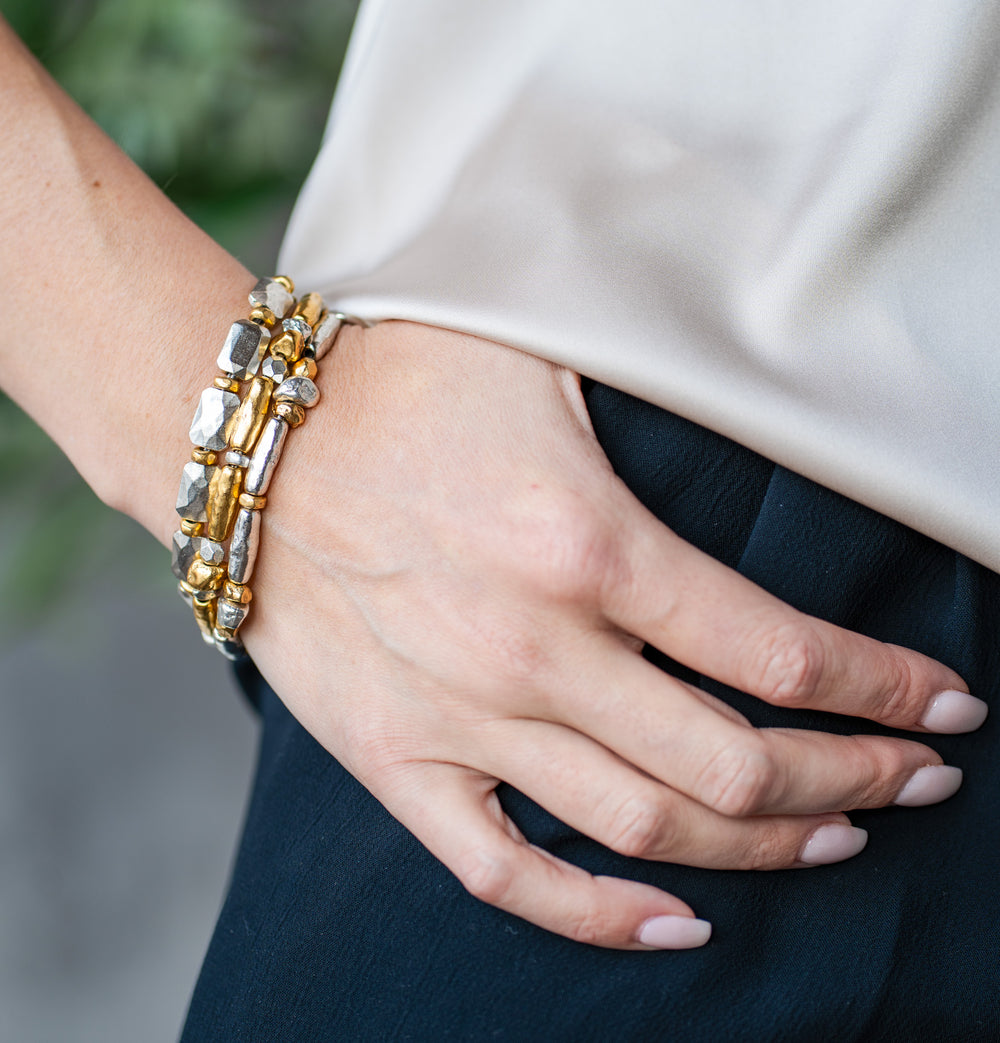 Gold and silver-toned bracelet with organically shaped mixed metal beads and a toggle clasp.