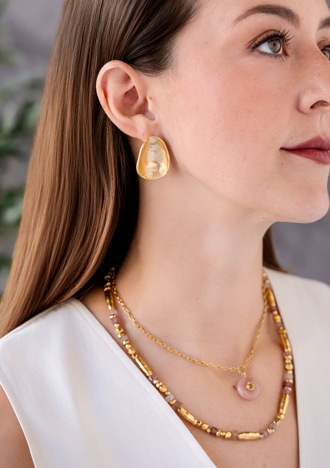 Matte gold sculptural scoop stud earrings with an organic curved shape and satin finish.