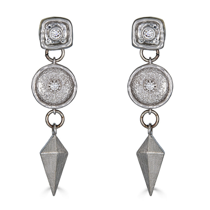 A matte silver dangle earring with a shield charm and a beautiful crystal connector.
