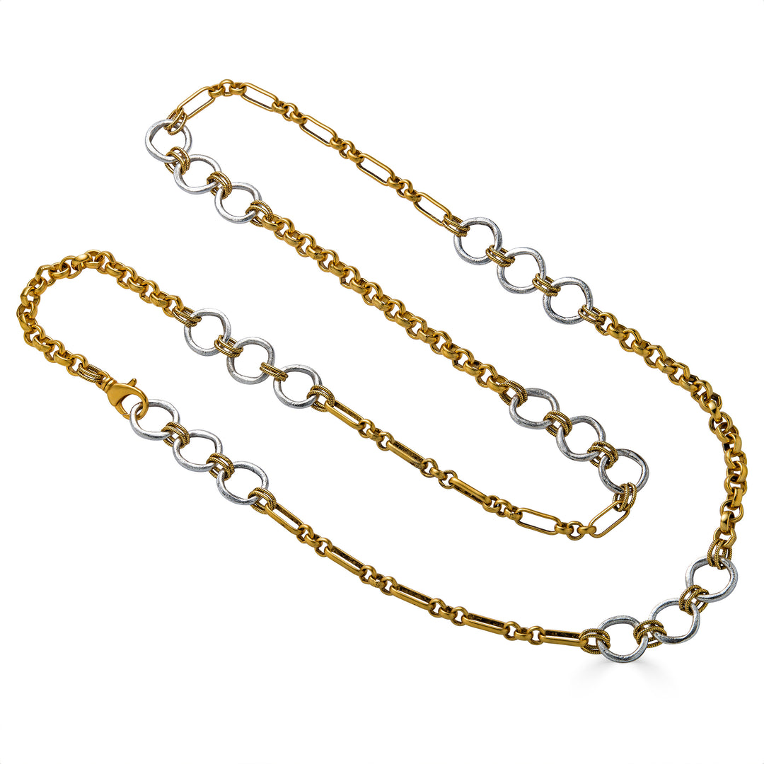Long mixed metal necklace with silver circle links, gold chain sections, and twisted rope connector details.