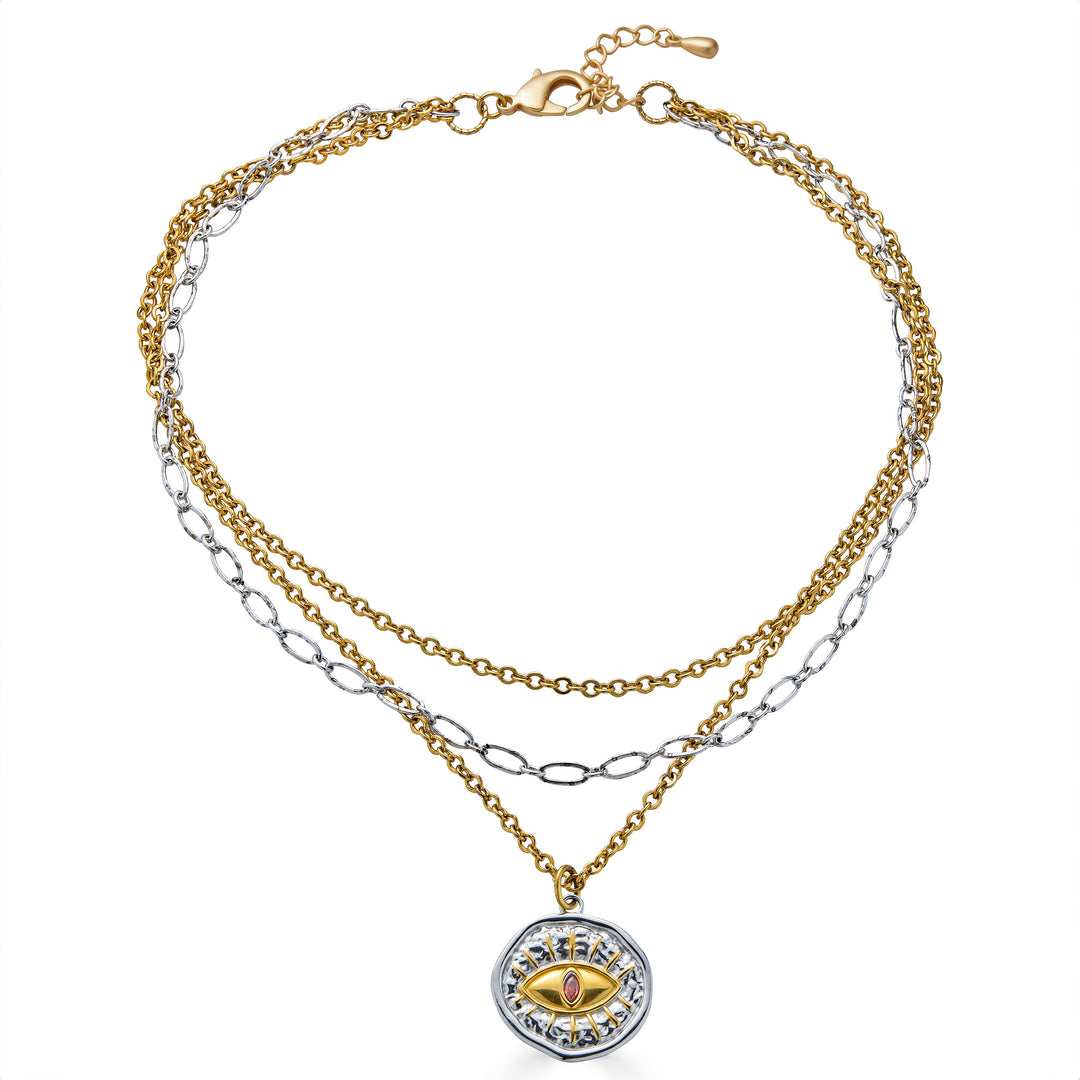 Mixed metal layered necklace with gold and silver chains and an eye pendant featuring a pink center stone.