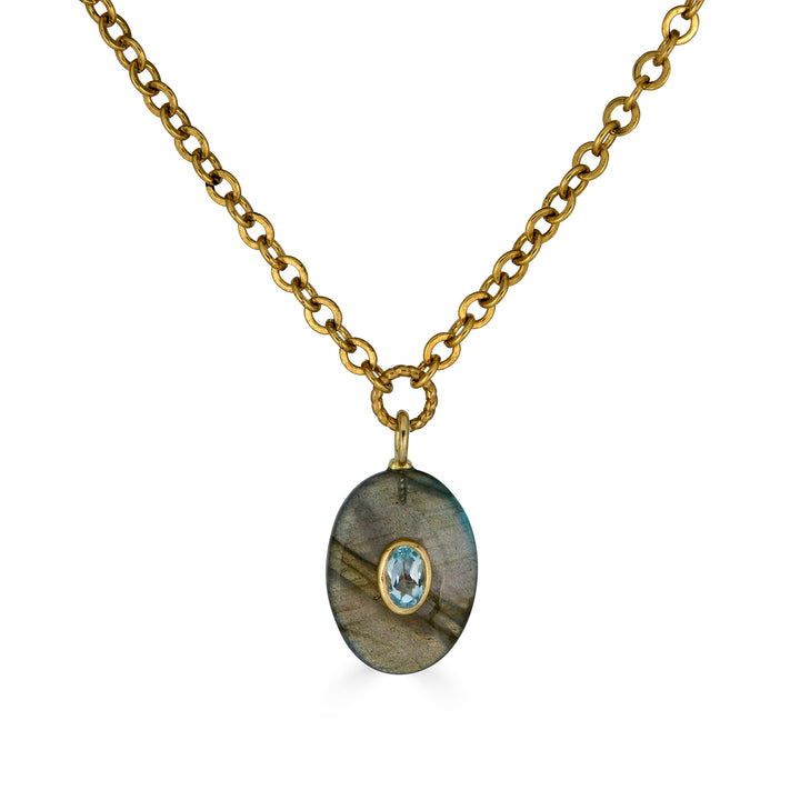 Oval labradorite pendant necklace with blue topaz inlay on a gold chain.