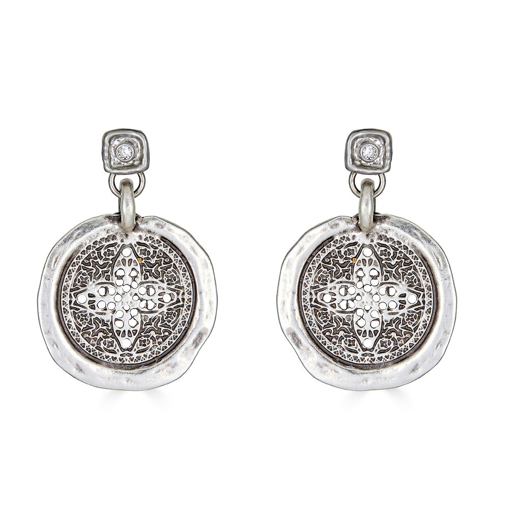 A silver filagree coin dangle earring on a crystal post.