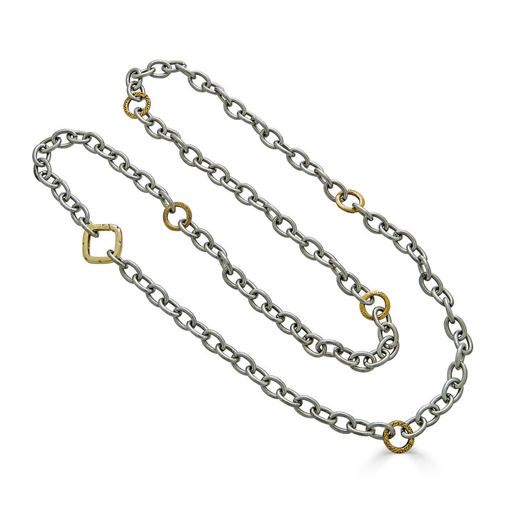 A silver layering chainlink necklace with gold accents and a square clasp.