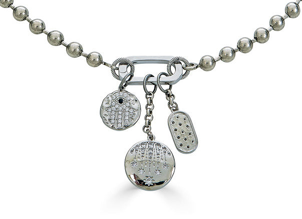 A ball chain charm necklace with fireworks, hamsa, and star charms on a snap clasp.