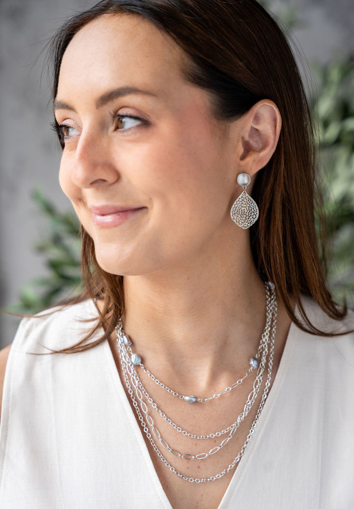 Rhodium-plated chain necklace featuring five gray keshi pearls spaced along the chain, shown in a circle on a white background.