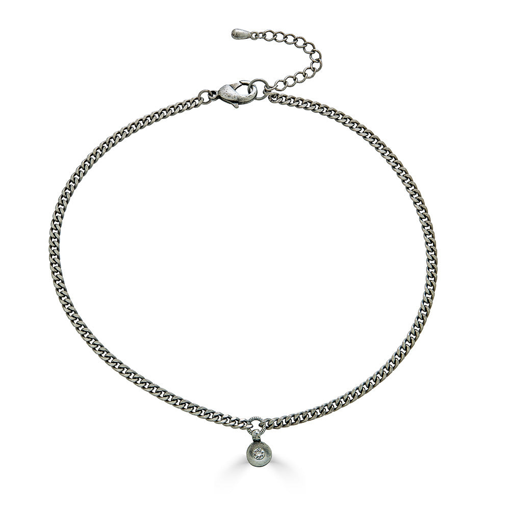 A delicate silver necklace with a small modern crystal pendant.
