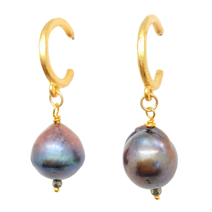 a black baroque pearl earring on a gold hoop