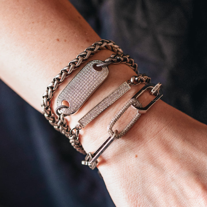 A woman's wrist modeling silver chainlink bracelets.