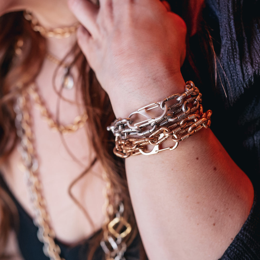 A woman's wrist modeling oval chain bracelets.