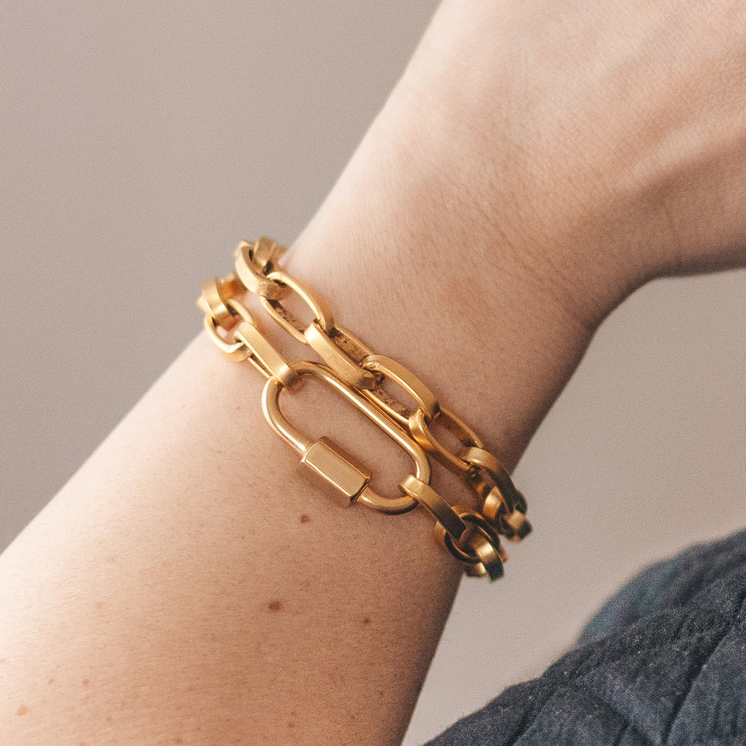 A woman's wrist modeling a double wrap gold chainlink bracelet.