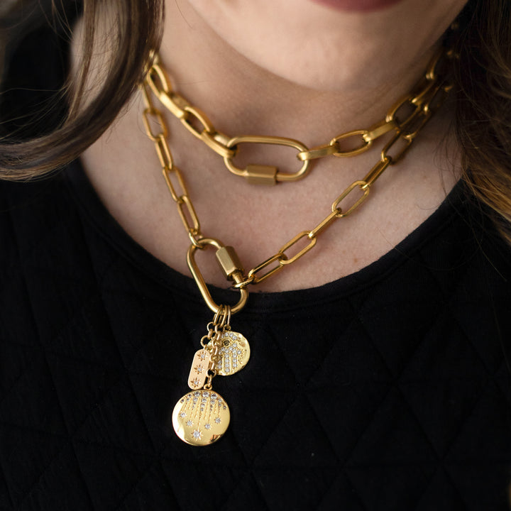 A woman's neck modeling gold chainlink necklaces.