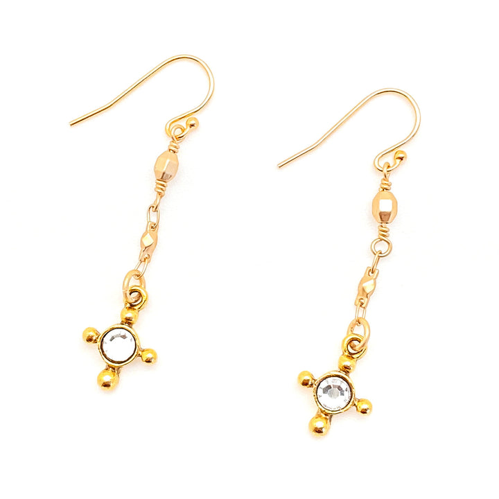 A pair of gold evencross drop earrings on a gold chain.