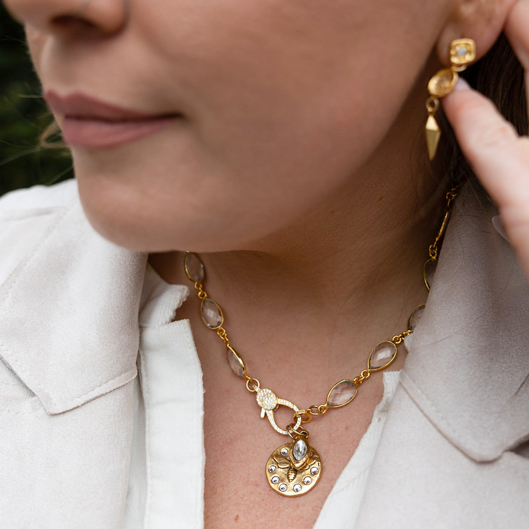 A gold crystal chain necklace with a crystal bee charm