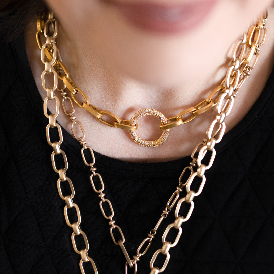 A model wearing layered chainlink necklaces.