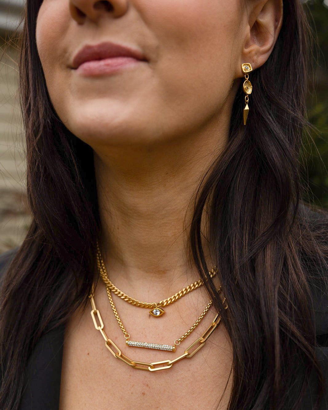 three necklaces with pave details. one with an evil eye and one with a bar.