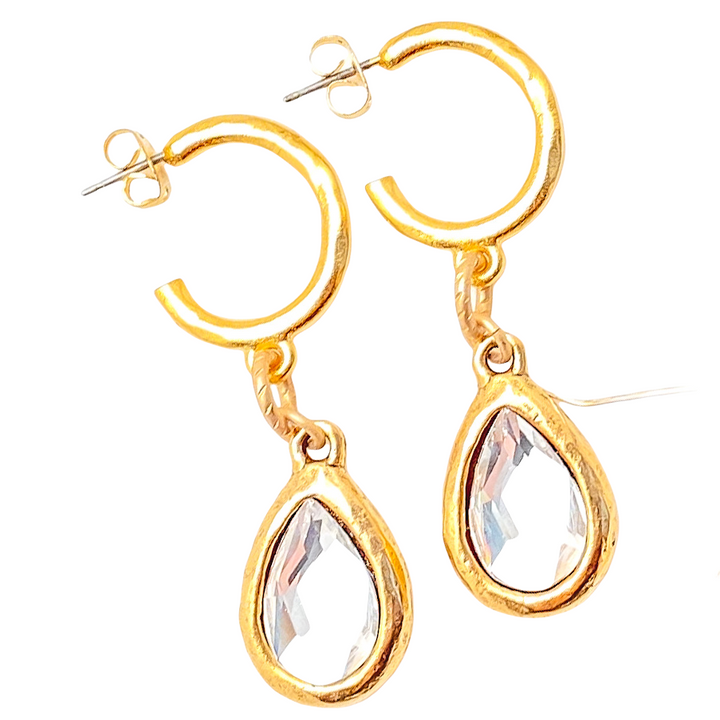 A pair of gold teardrop crystal hoop earrings.
