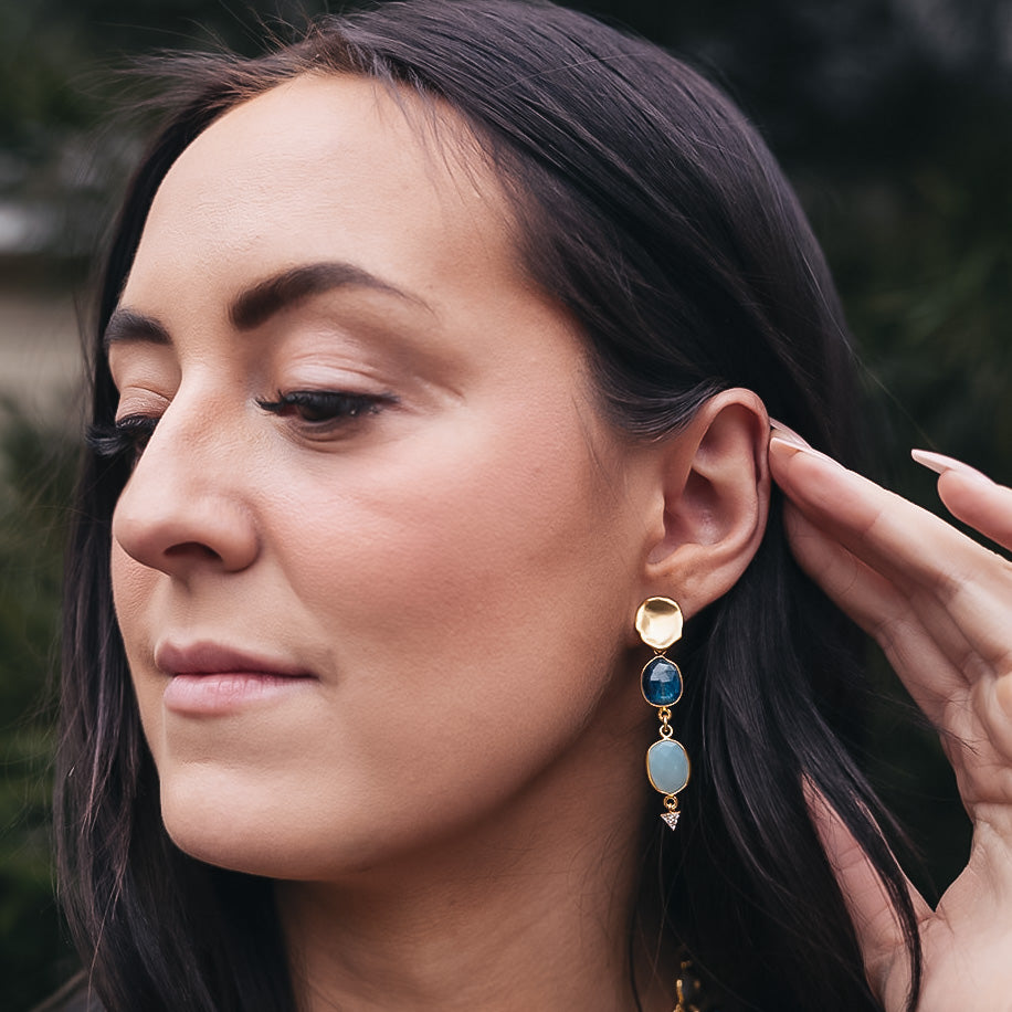 a pair of earring with bezel set kyanite and aquamarine stones on a lotus leaf post