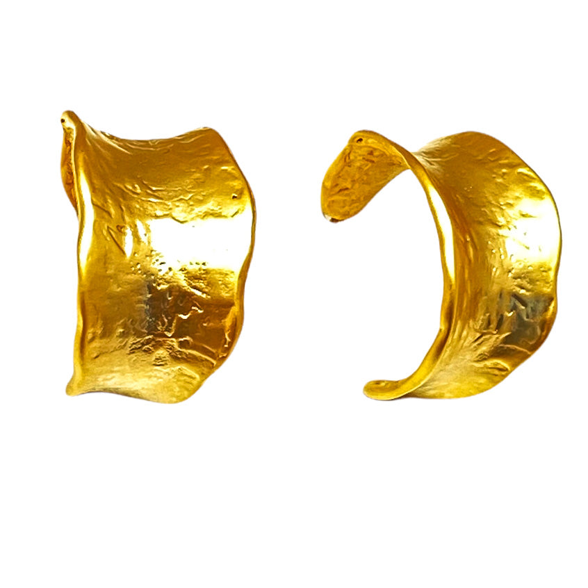 A pair of matte gold post hoop earrings with irregular shape and texture.