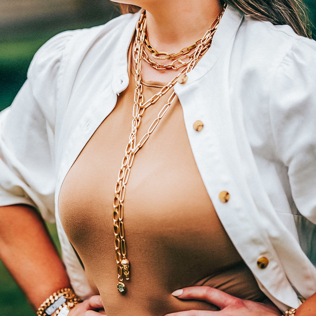 A model wearing layered chainlink necklaces.