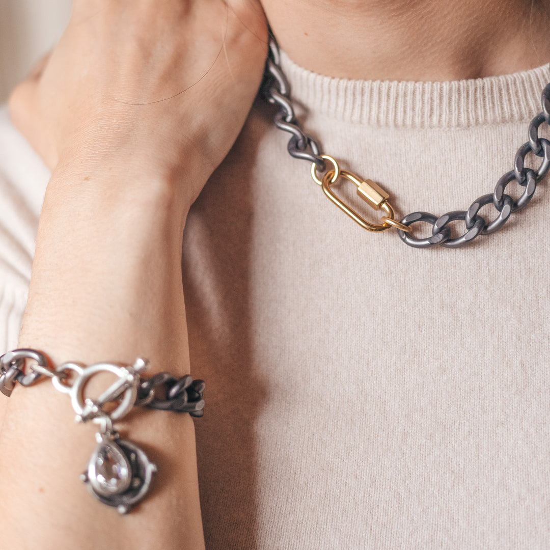 A model wearing a chainlink gunmetal necklace and bracelet.