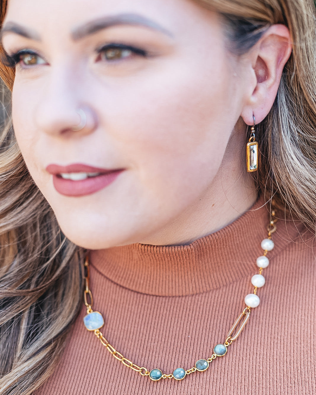 A woman wearing a Mixed Gemstone Necklace with Labradorite, Moonstone and Pearls