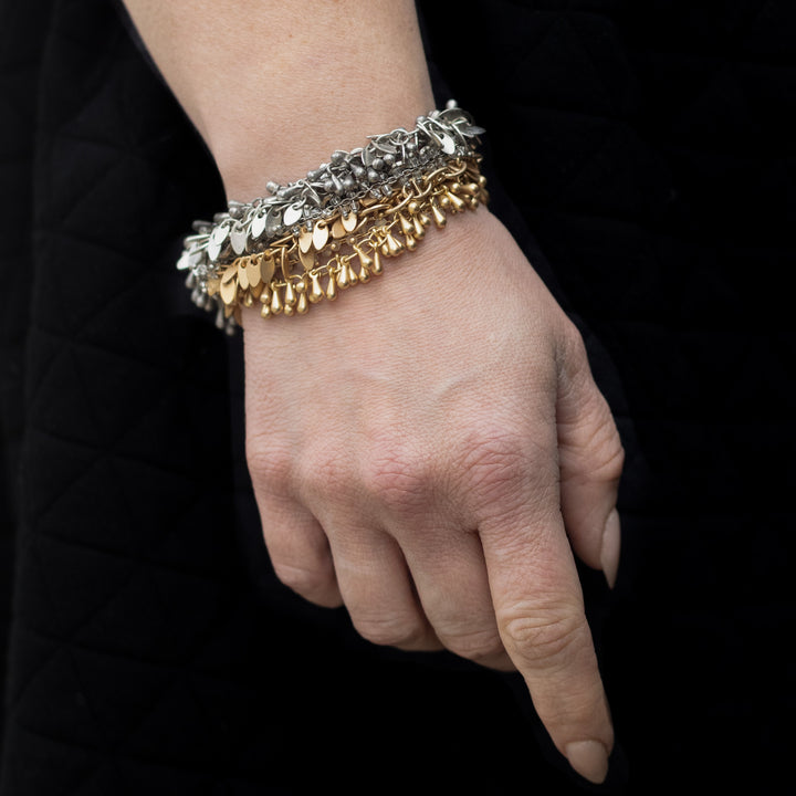 A woman's wrist modeling fringe bracelets.