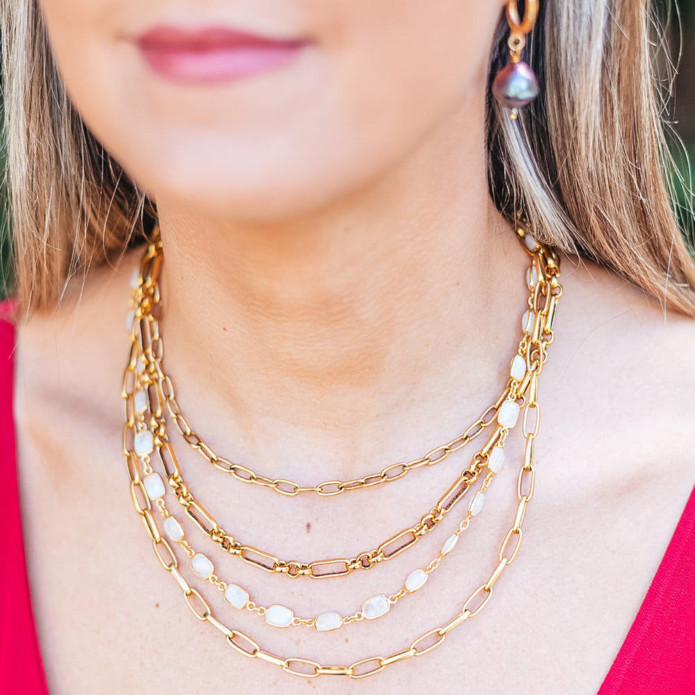A model wearing A gold multi strand necklace with moonstones