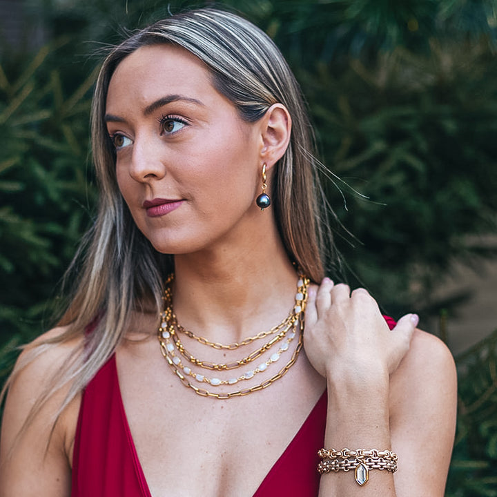 A model wearing A gold multi strand necklace with moonstones
