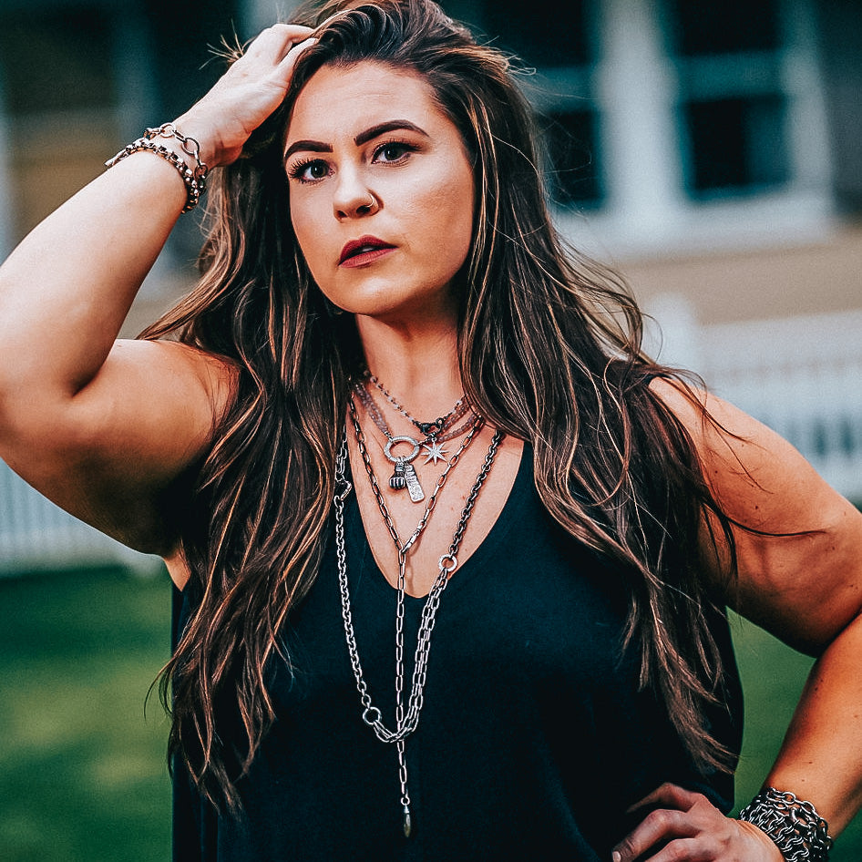 A model wearing layered chainlink necklaces.