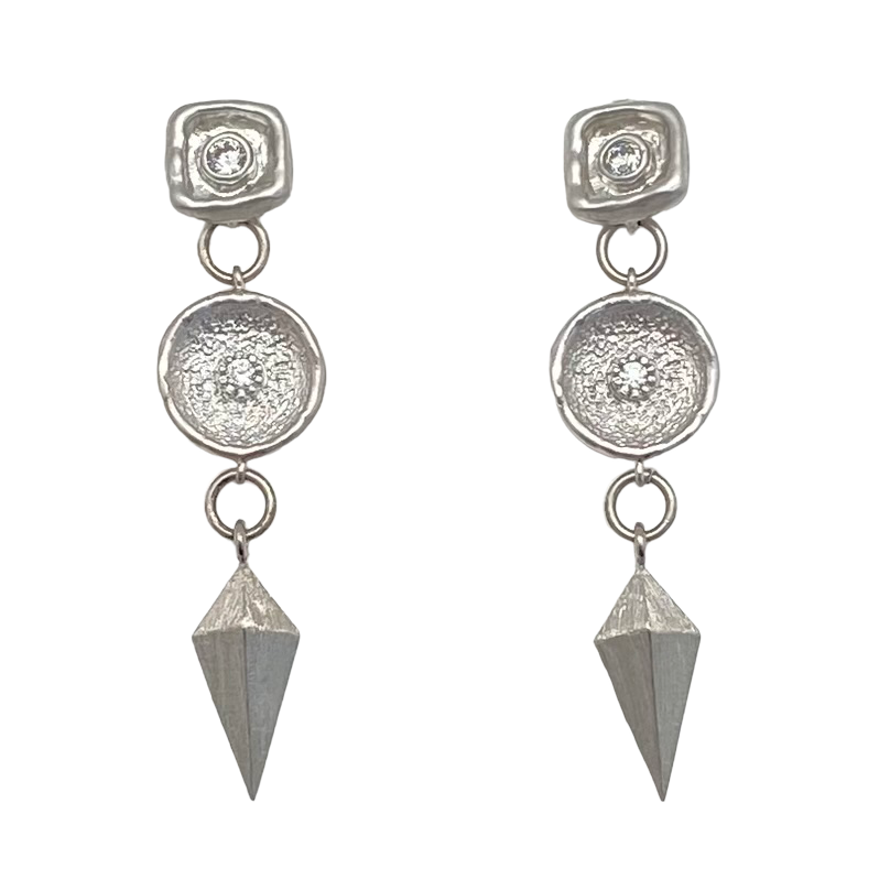 A matte silver dangle earring with a shield charm and a beautiful crystal connector.