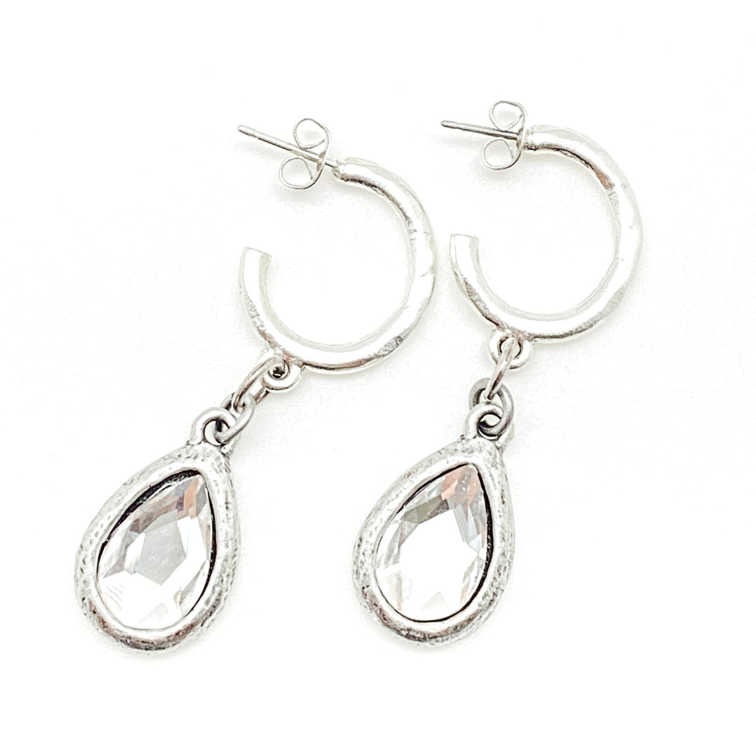 A pair of silver teardrop crystal hoop earrings.