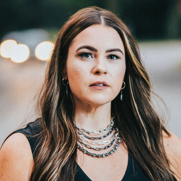 A model wearing layered chainlink necklaces.