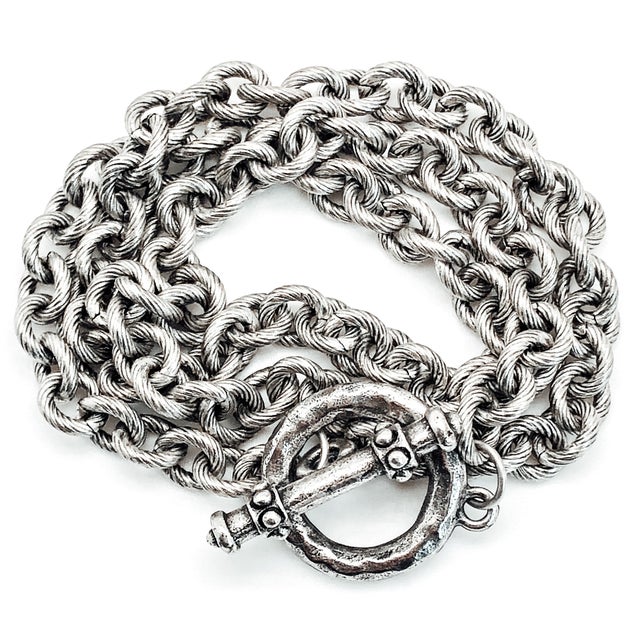 A triple wrap silver bracelet or necklace with round textured chain links.